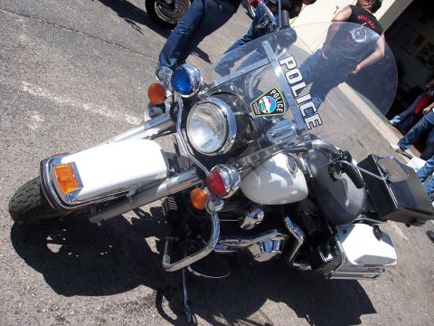 1972 Ford Ranchero - A police motorcycle is parked on asphalt, with people in the background.