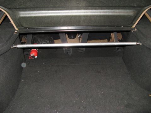 1995 Ford Probe - Trunk interior shows a strut bar and a fire extinguisher, not a 1995 Ford Probe.