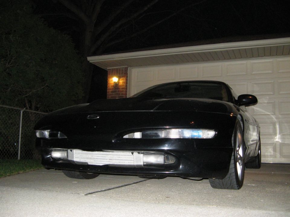 Black car front end with exposed intercooler and aftermarket headlights