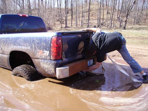 2000 Chevrolet Tahoe - A person attempts to free a stuck pickup truck from a muddy mire.
