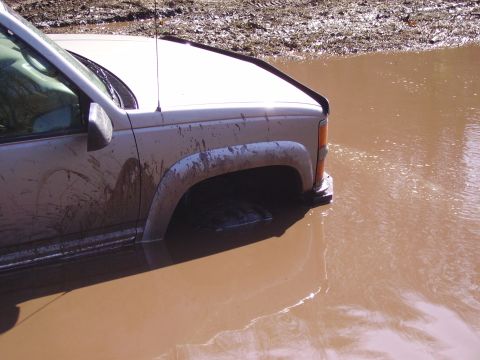 2000 Chevrolet Tahoe - This vehicle is stuck in a muddy puddle, with only the front half visible.