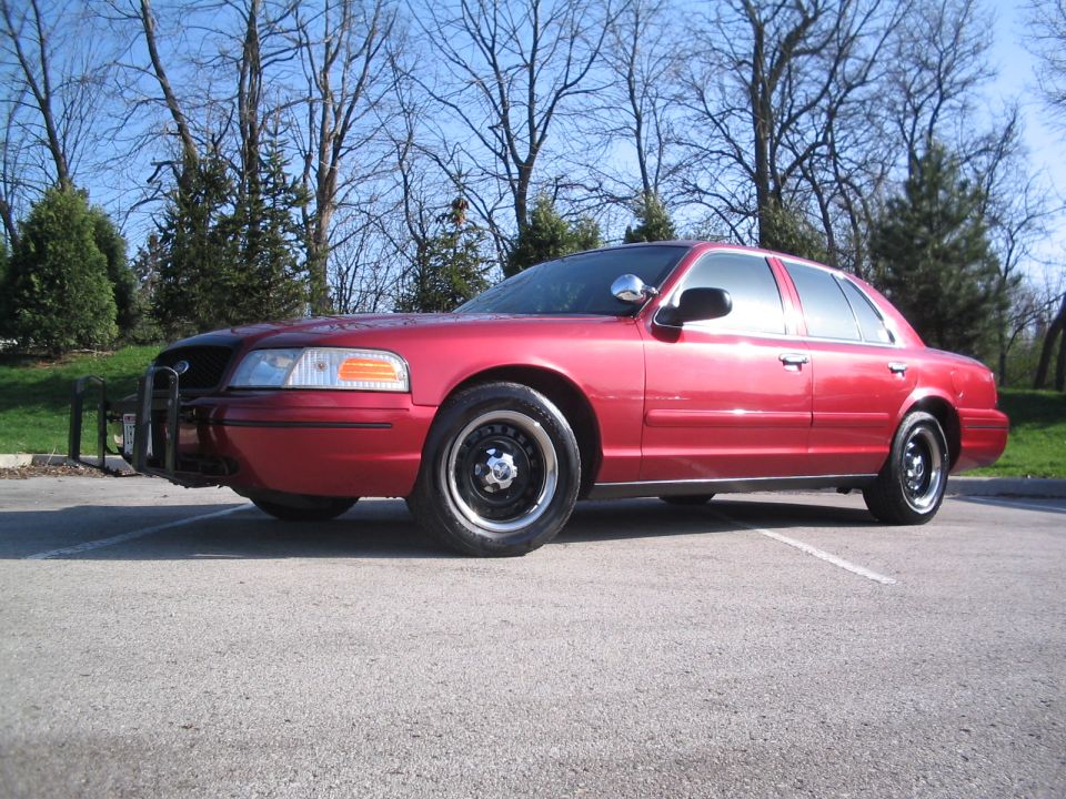 Red sedan with a push bumper parked outside