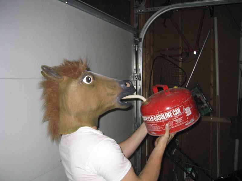 Person in horse mask drinking from red gasoline can