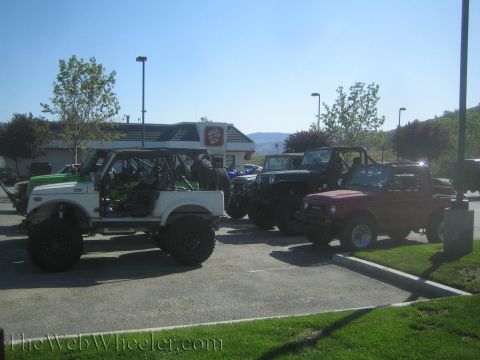 1987 Suzuki Samurai - Several off-road vehicles, including Suzuki Samurai models and a Jeep, are parked in a lot near a Jack in the Box.