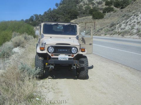 1987 Suzuki Samurai - This Toyota Land Cruiser is parked on the side of a road in a dry, hilly area.