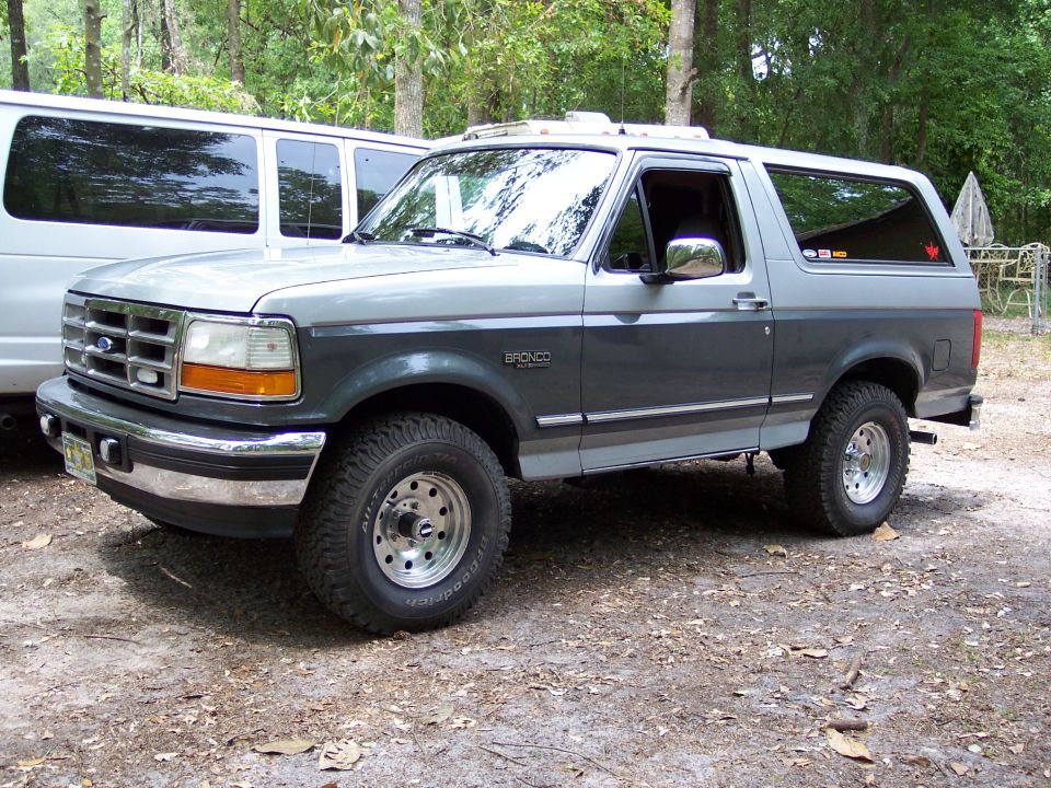 Two-tone gray 1996 Ford Bronco parked next to a white van