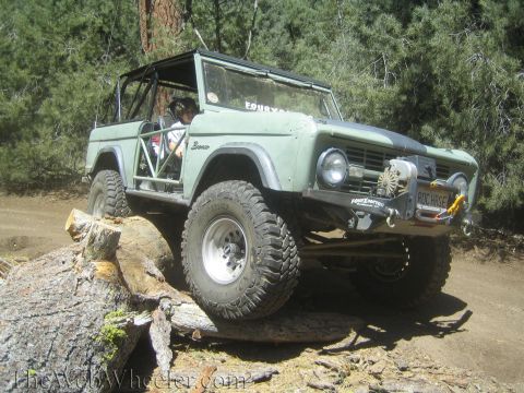 1987 Suzuki Samurai - First-gen Ford Bronco tackling an obstacle on an off-road trail.