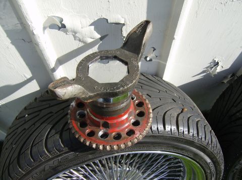 1996 Ford Probe - Tool and wheel parts are laid out on a tire against a white wall.