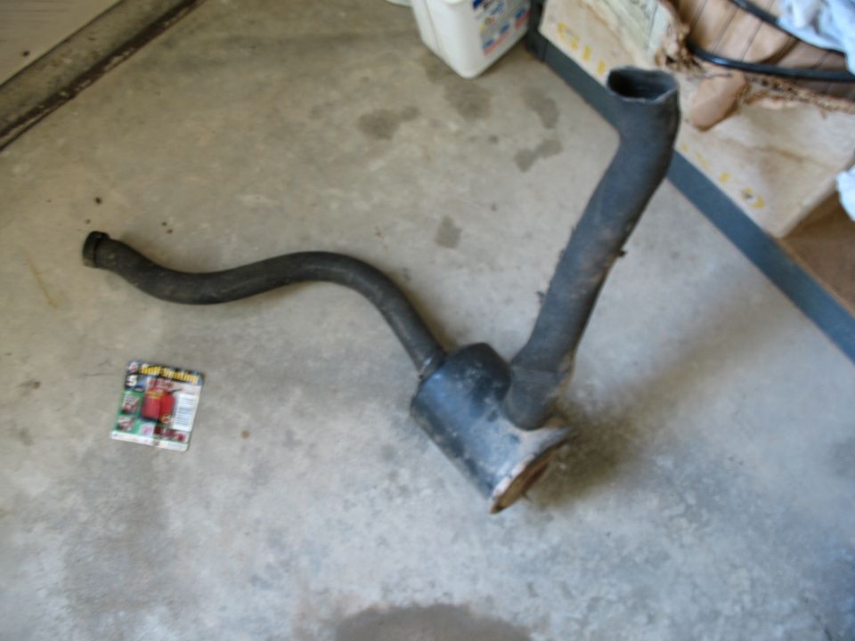 Exhaust pipe and muffler on concrete floor with magazine