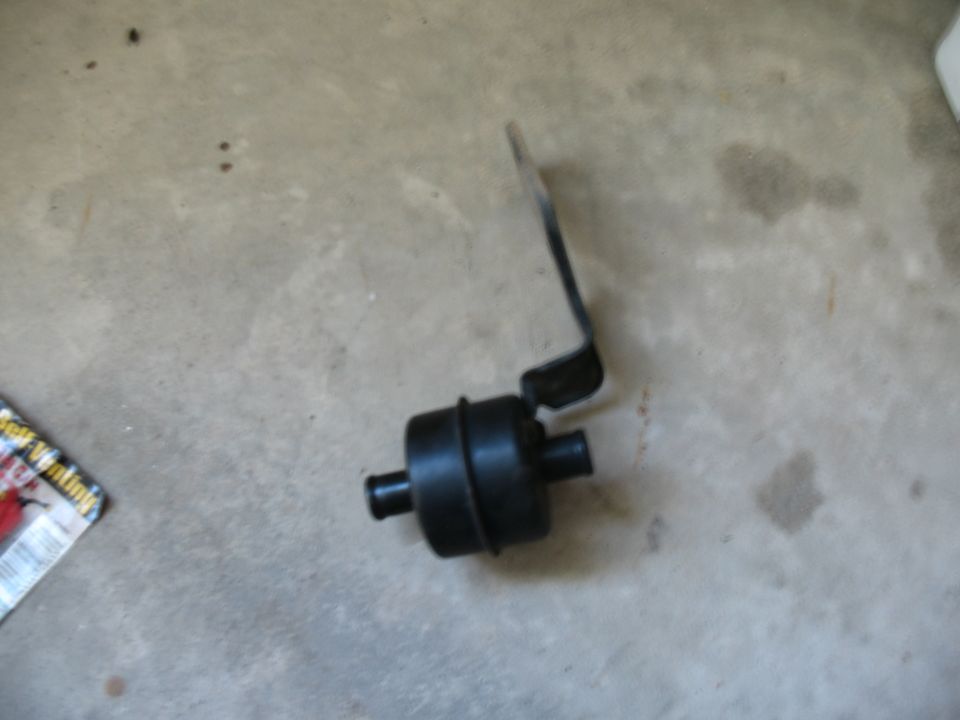 Black automotive part with metal bracket on concrete floor