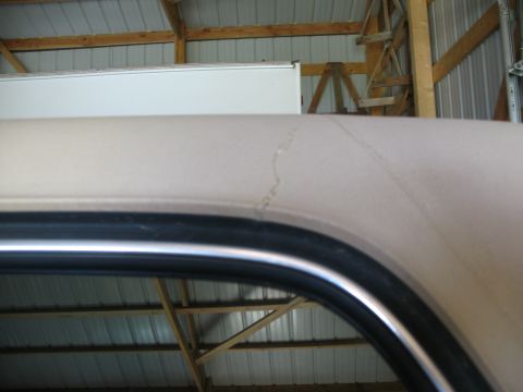 1989 Ford Bronco - A cracked paint job on a vehicle's roofline is visible inside a garage.