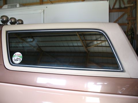 1989 Ford Bronco - This SUV, possibly a Ford Bronco, is shown from the side with a beige top and a circular sticker on the rear window.