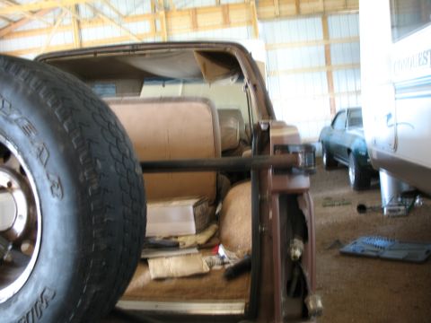 1989 Ford Bronco - The interior of an older Ford Bronco is visible, with a spare tire obscuring part of the view.