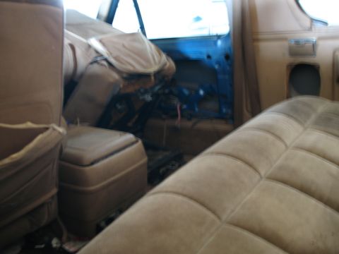 1989 Ford Bronco - Interior of a vehicle showing disassembled parts and exposed wiring behind the door panel.