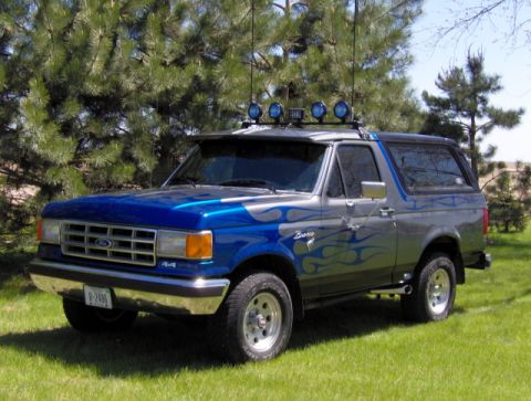 1987 Ford Bronco - This 1987 Ford Bronco features a two-tone paint job with flame graphics and auxiliary lighting.