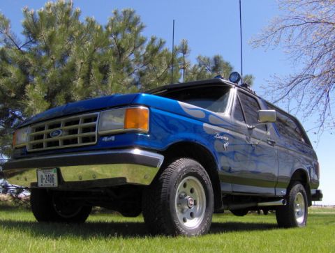 1987 Ford Bronco - This 1987 Ford Bronco is a classic SUV with a distinctive blue paint job and flame decals.