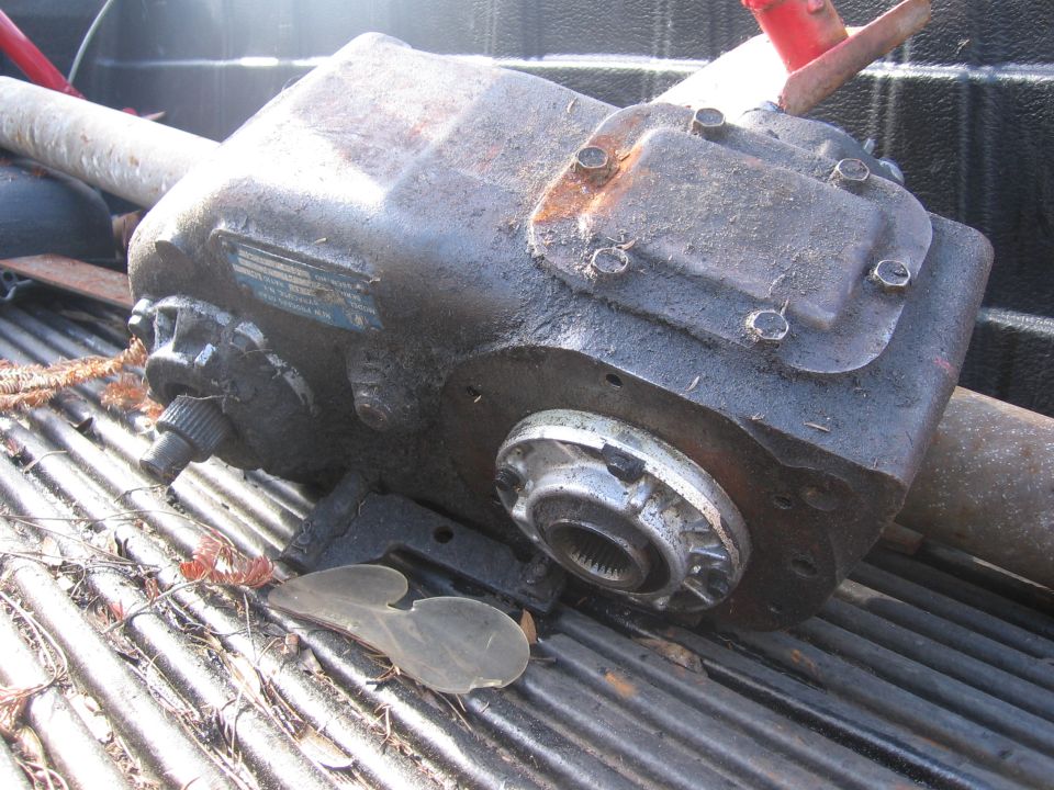 Used power steering gearbox with a metal tag on the side, resting in a truck bed