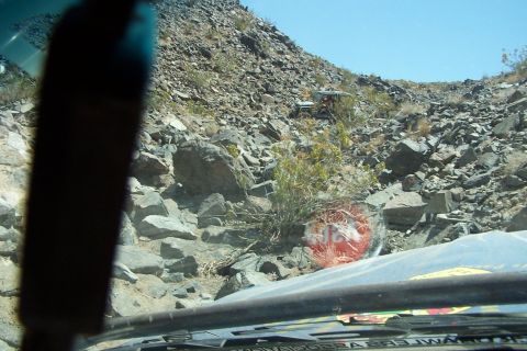 1990 Ford Bronco - Two vehicles are visible in the distance on a rocky off-road trail.