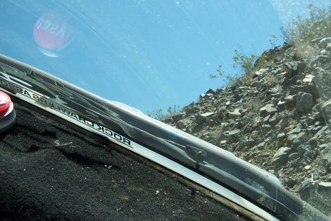 1990 Ford Bronco - Interior view of a vehicle's windshield, showing a 'ROCK CRAWLER' decal and a reflection of a red sticker.