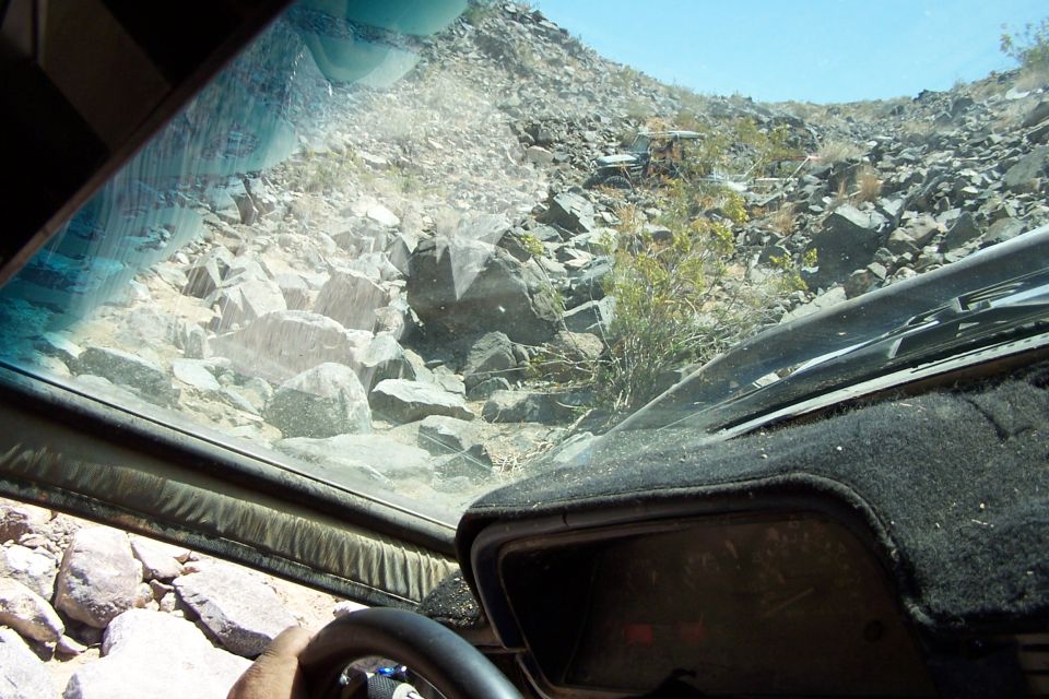Interior view of a vehicle on a rocky trail, showing dashboard and windshield