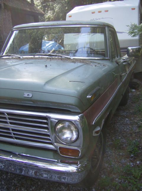 1986 Ford Bronco - This vintage Ford pickup, likely from the early 1970s, is seen from a three-quarter front angle while hitched to a travel trailer.