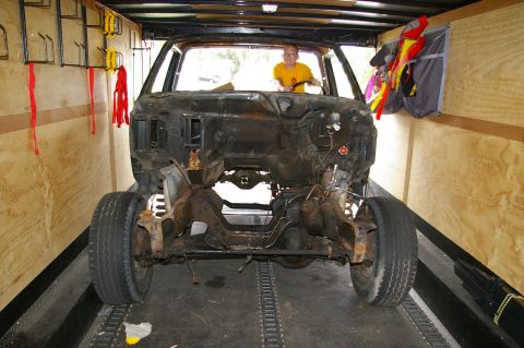 1986 Ford Bronco - A disassembled car chassis is loaded into a trailer, awaiting restoration.