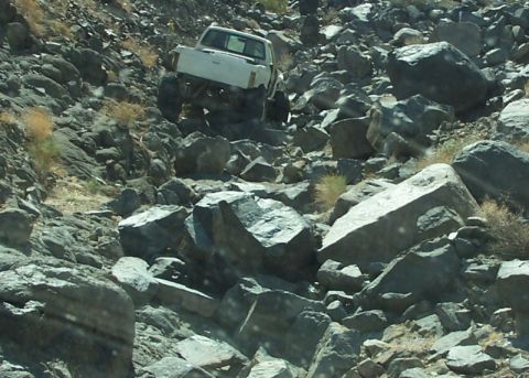 1990 Ford Bronco - A white 1990 Ford Bronco tackles a challenging rocky trail.