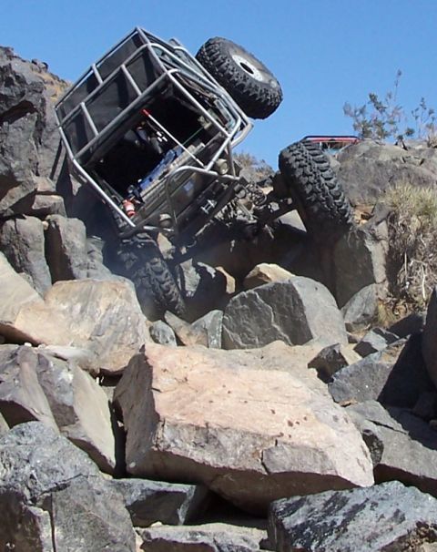 1990 Ford Bronco - This heavily modified buggy is navigating a difficult rocky terrain.