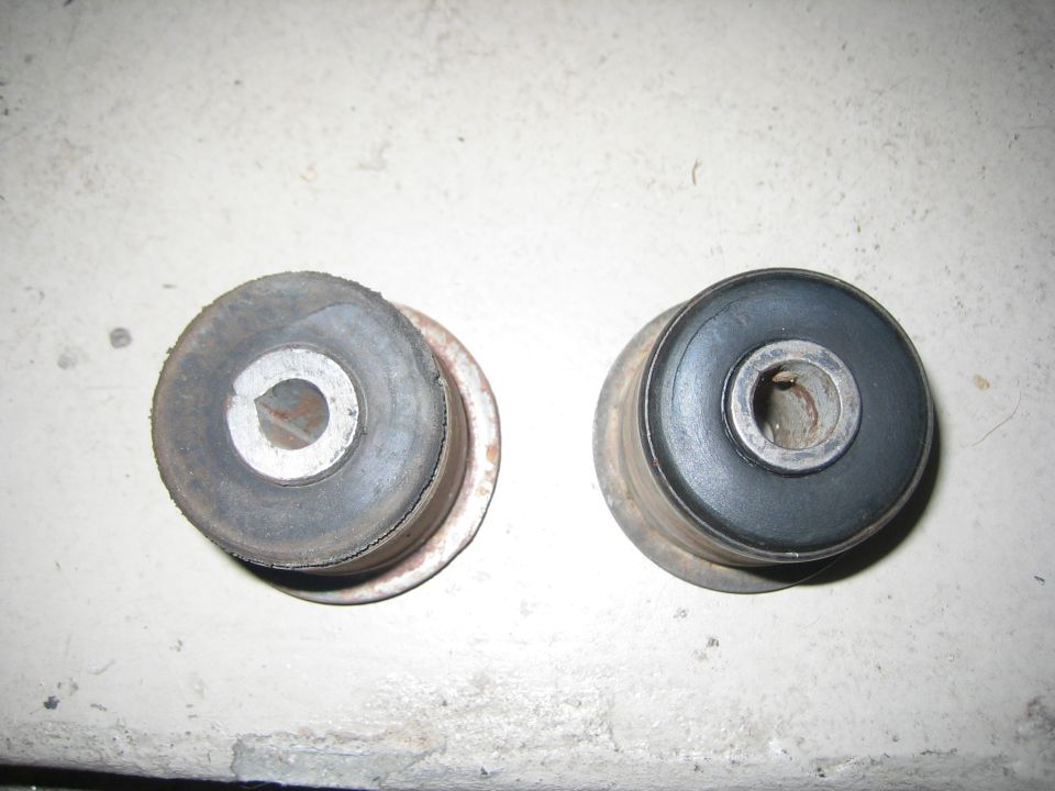 Two rubber and metal suspension bushings, one looks worn