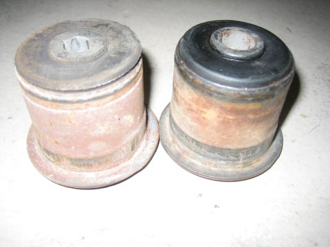 2001 Jeep Wrangler - Two worn bushings, one with a black rubber insert, are shown against a white background.