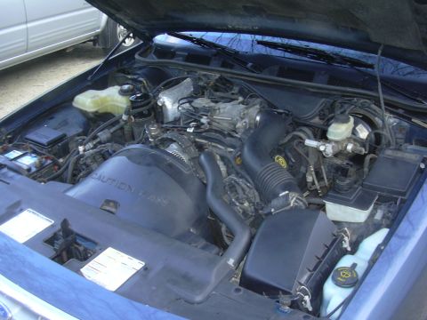 1996 Ford Crown Victoria - The engine bay of a 1996 Ford Crown Victoria is shown with the hood open, revealing the engine and various components.