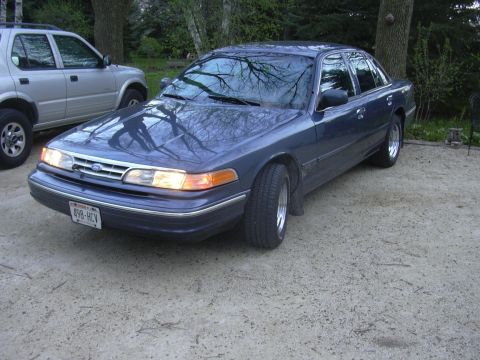 1996 Ford Crown Victoria - Dark blue 1996 Ford Crown Victoria seen parked outside with a silver SUV nearby.
