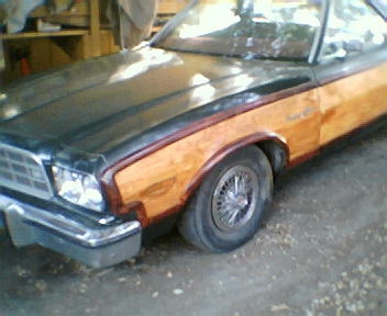 1973 Ford Ranchero - This vehicle has wood grain paneling on its side, with a chrome bumper and grille visible.