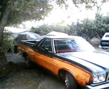 1973 Ford Ranchero - This 1973 Ford Ranchero pickup truck is parked outdoors with a two-tone orange and black paint scheme.