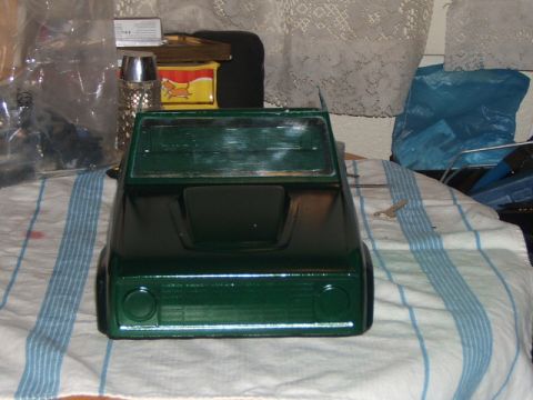 1988 Ford Bronco - A green toy truck body sits on a striped cloth, with various household items in the background.