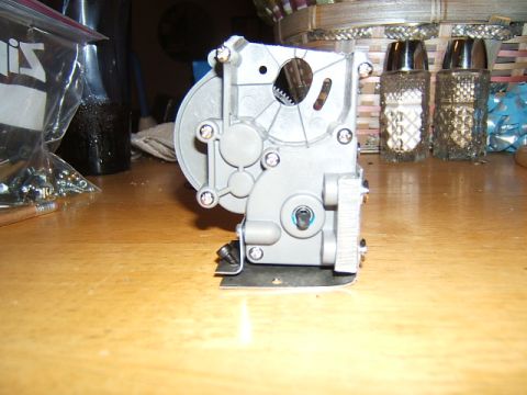 1988 Ford Bronco - A close-up view of a plastic gearbox with exposed gears and mounting hardware.
