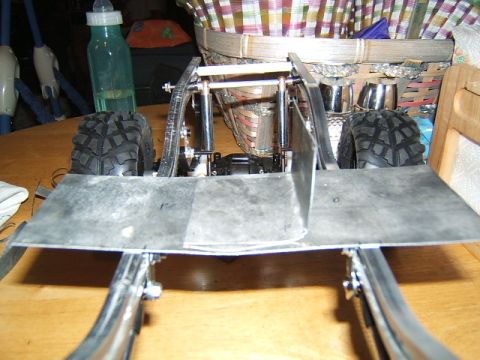 1988 Ford Bronco - The chassis of a remote control vehicle is shown, metal plating and off-road tires.