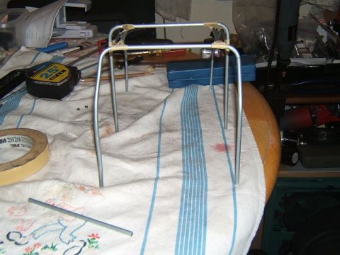 1988 Ford Bronco - A metal frame assembly with tape and legs sits on a cloth next to a tape measure.