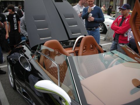 1998 Ford Crown Victoria - Tan diamond-quilted leather cockpit of a black convertible supercar viewed at an outdoor car show with spectators.