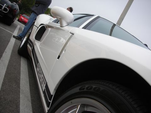1998 Ford Crown Victoria - Low angled side shot of a white Ford GT highlighting its door intake scoop, mirror and Goodyear-tired wheel.