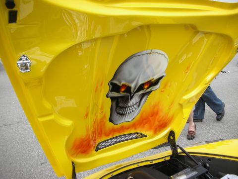 1998 Ford Crown Victoria - raised yellow hood underside displays an airbrushed gray skull with glowing eyes amid orange flames.