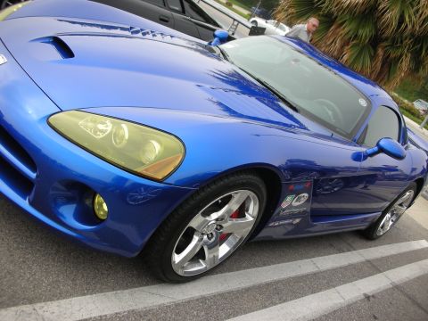 1998 Ford Crown Victoria - Low angled shot of a blue Dodge Viper's hood scoops, fender vent and chrome wheel with event decals on the door.