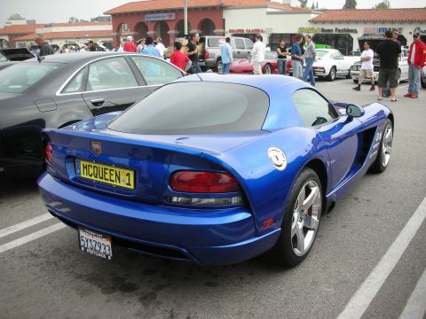 1998 Ford Crown Victoria - blue Dodge Viper coupe is parked rear three-quarter showing its taillights and yellow MCQUEEN 1 plate at a busy show.