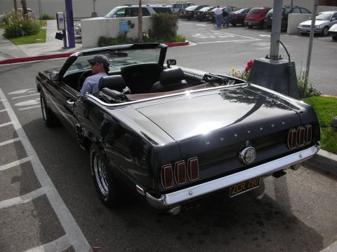 1998 Ford Crown Victoria - black classic Ford Mustang convertible seen from the rear three-quarter with a driver seated, California plate ZCR 790.