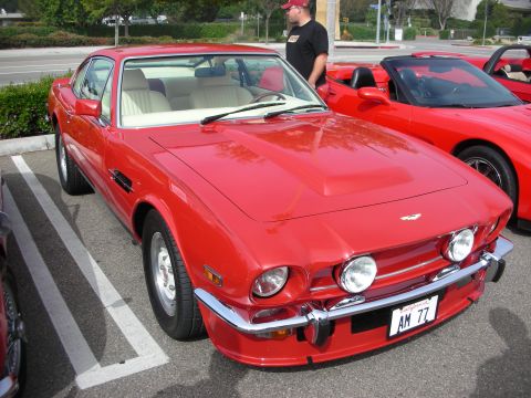 1998 Ford Crown Victoria - red Aston Martin V8 coupe shown front three-quarter with quad headlights and a front plate reading AM 77.