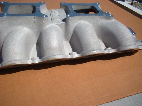 1964 Ford 427 - Close-up of an aluminum intake manifold with visible text on its surface.