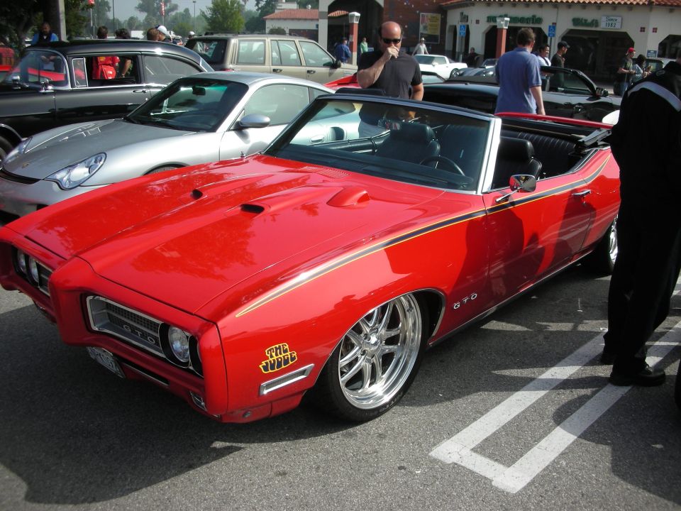 Side view of red Pontiac GTO Judge convertible with chrome wheels