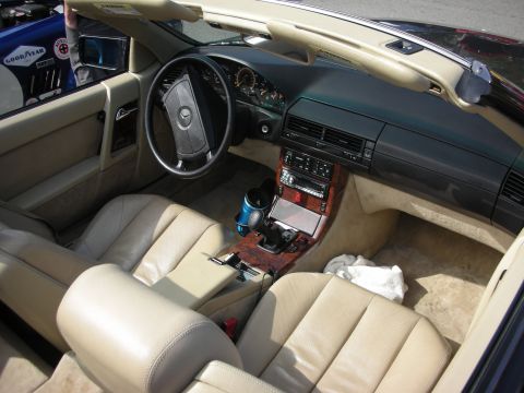 1998 Ford Crown Victoria - Interior of a Mercedes-Benz SL roadster showing tan leather seats, wood-trimmed console and the Mercedes steering wheel.