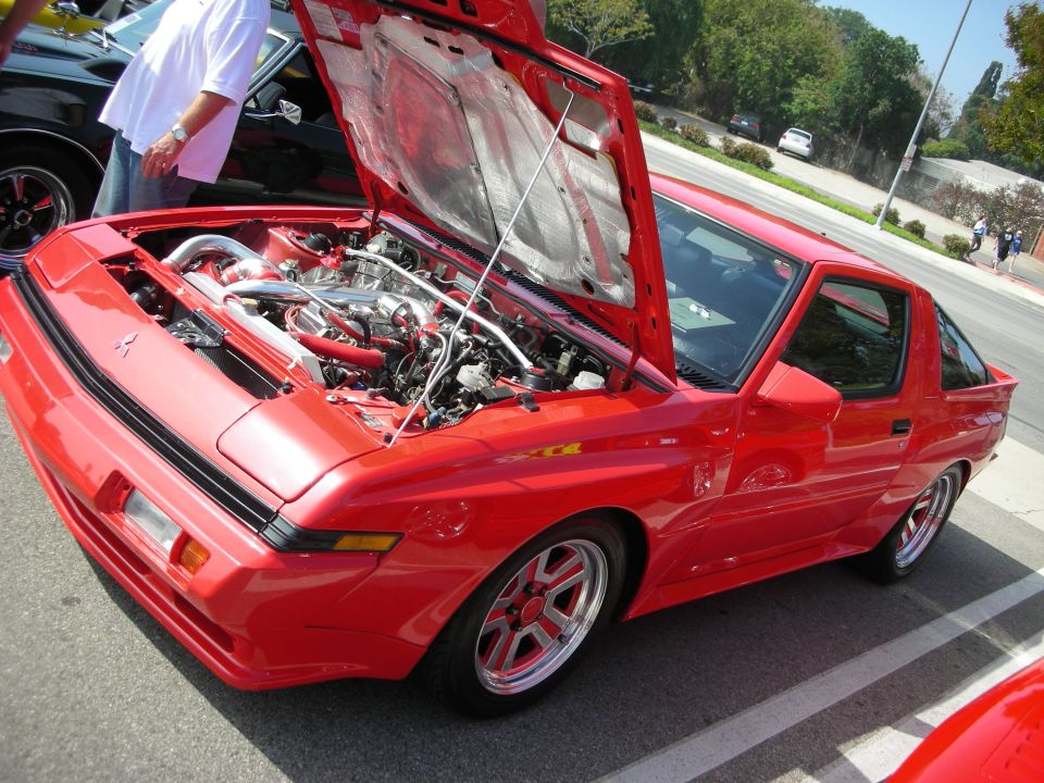 Red turbocharged sports coupe with hood open at car show