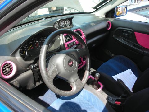 1998 Ford Crown Victoria - Interior of a Subaru WRX STi featuring pink-trimmed vents and console, blue suede seats and a leather steering wheel.